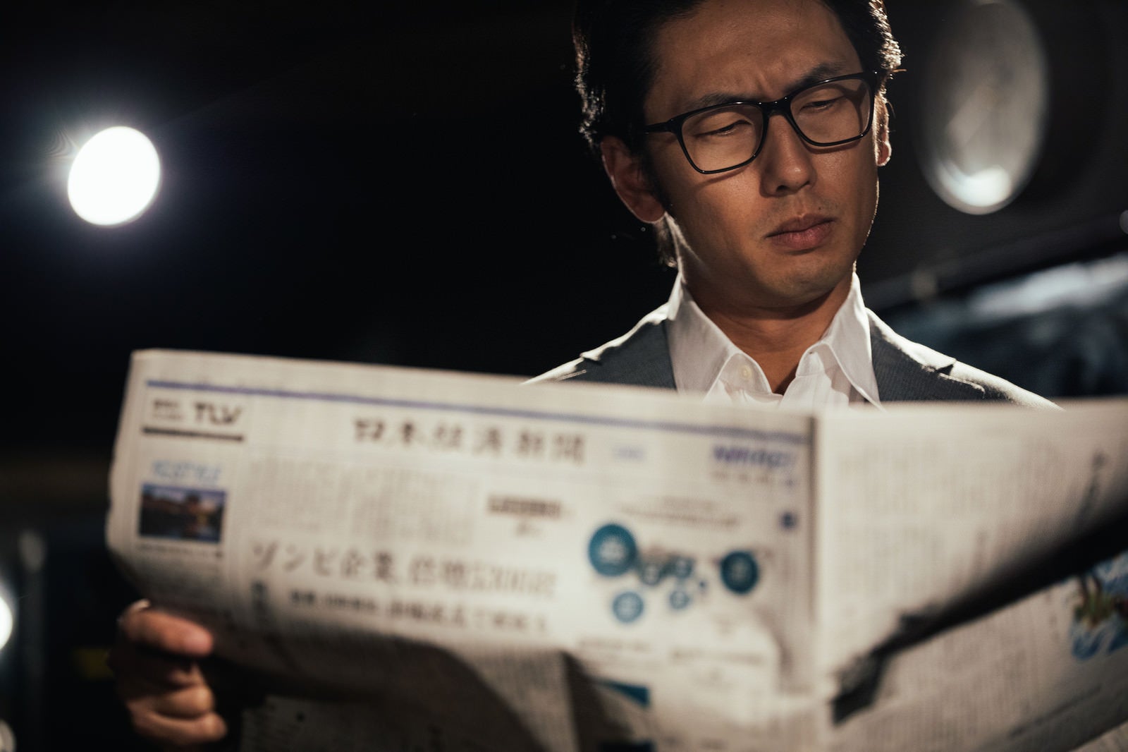 「経済新聞を広げるビジネスマン」の写真［モデル：大川竜弥］