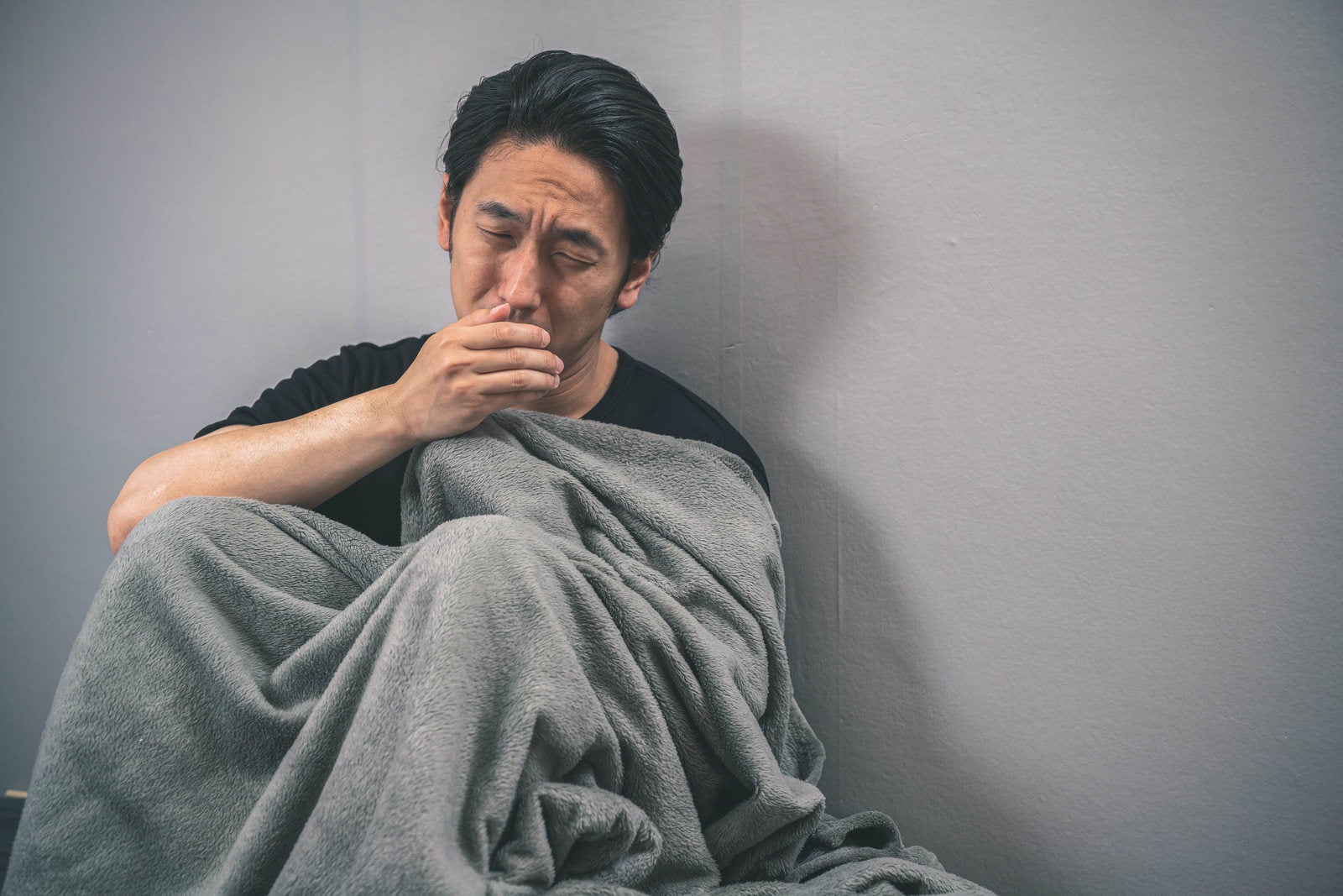 「夏風邪で咳がとまらない男性」の写真［モデル：大川竜弥］