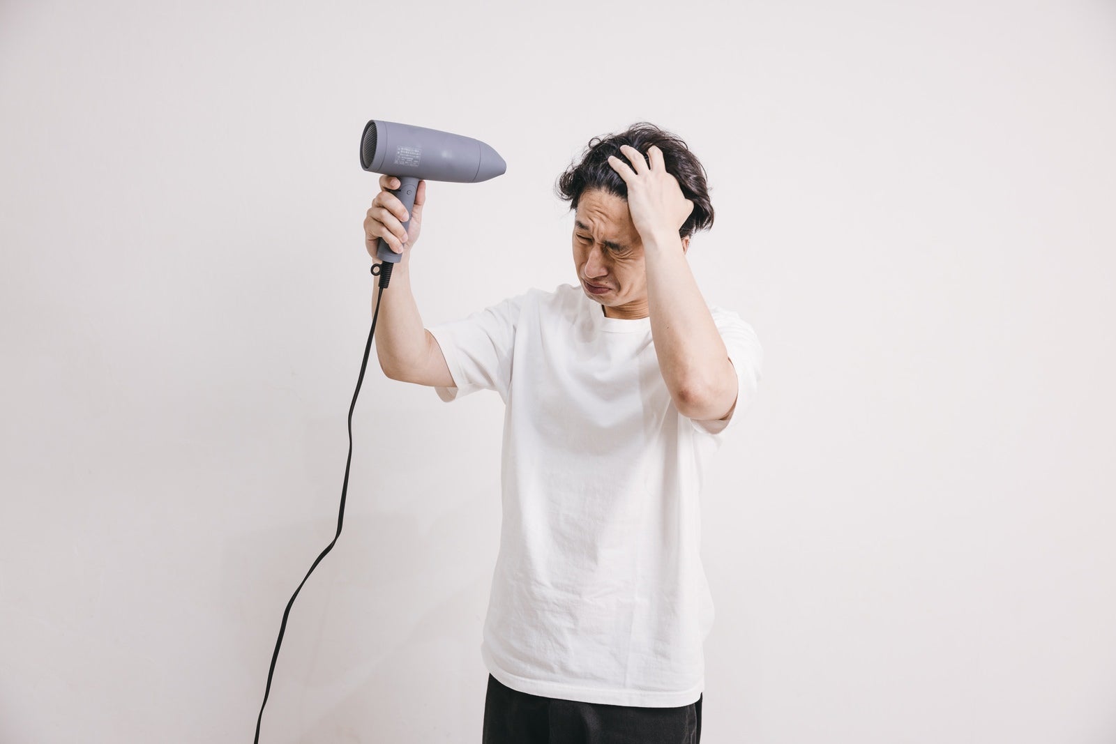 「ドライヤーで髪を乾かす男性」の写真［モデル：大川竜弥］