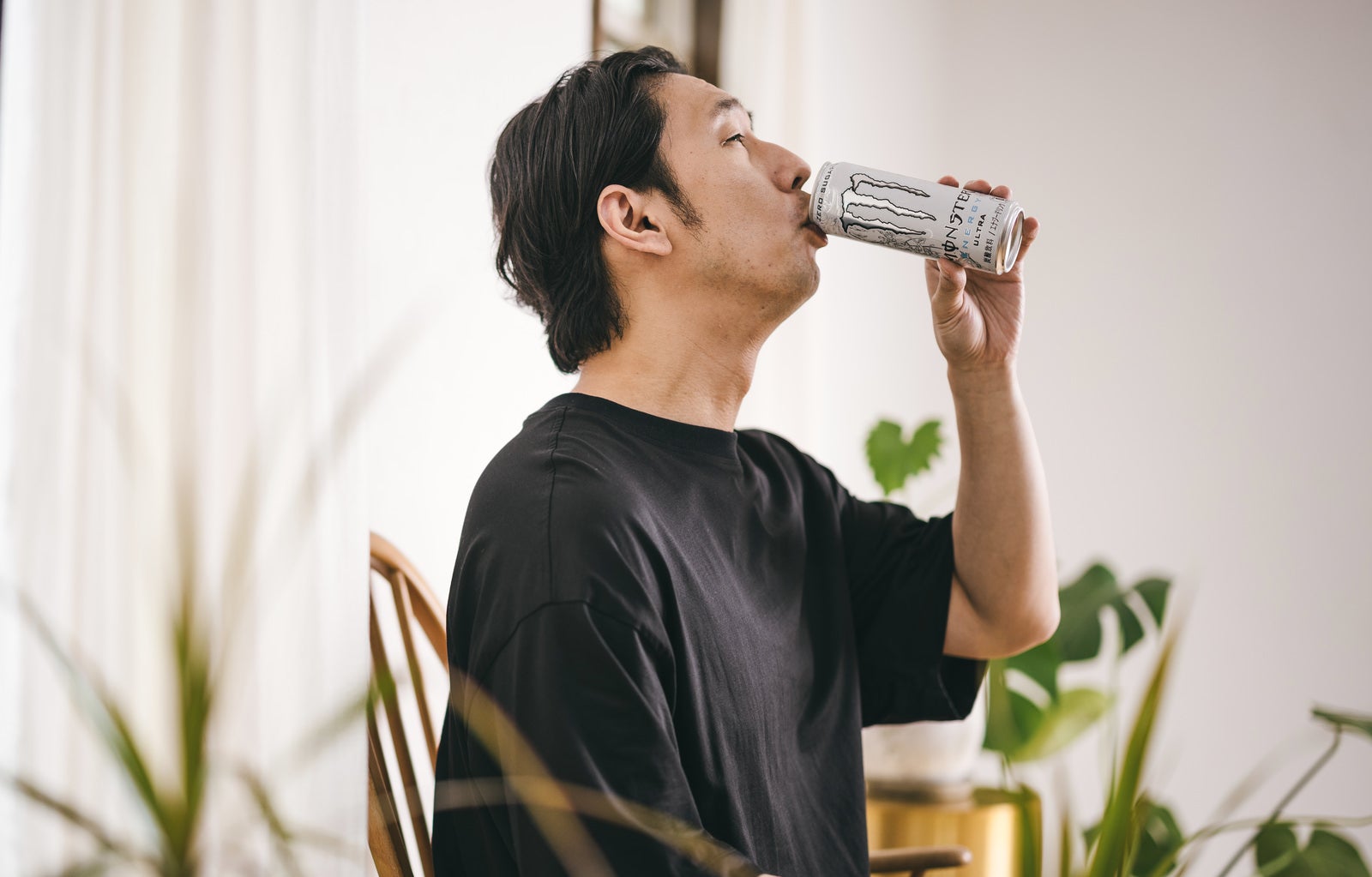 「白いエナジードリンクを飲む男性」の写真［モデル：大川竜弥］