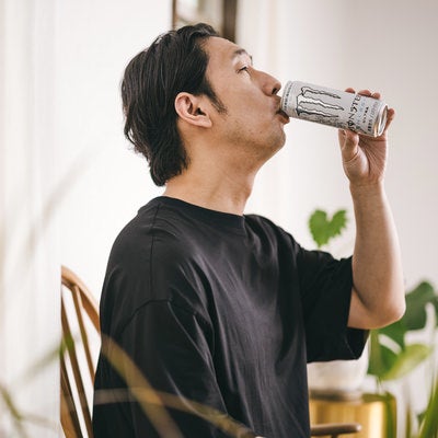 白いエナジードリンクを飲む男性の写真