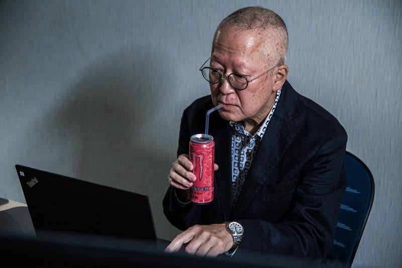 ピンモン飲んで残業がんばる高齢者の写真