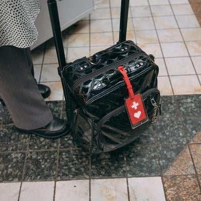 ヘルプマーク付きキャリーケースを引く女性の様子の写真