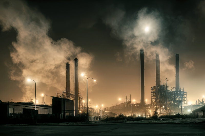 工場夜景と煙突からの煙の写真