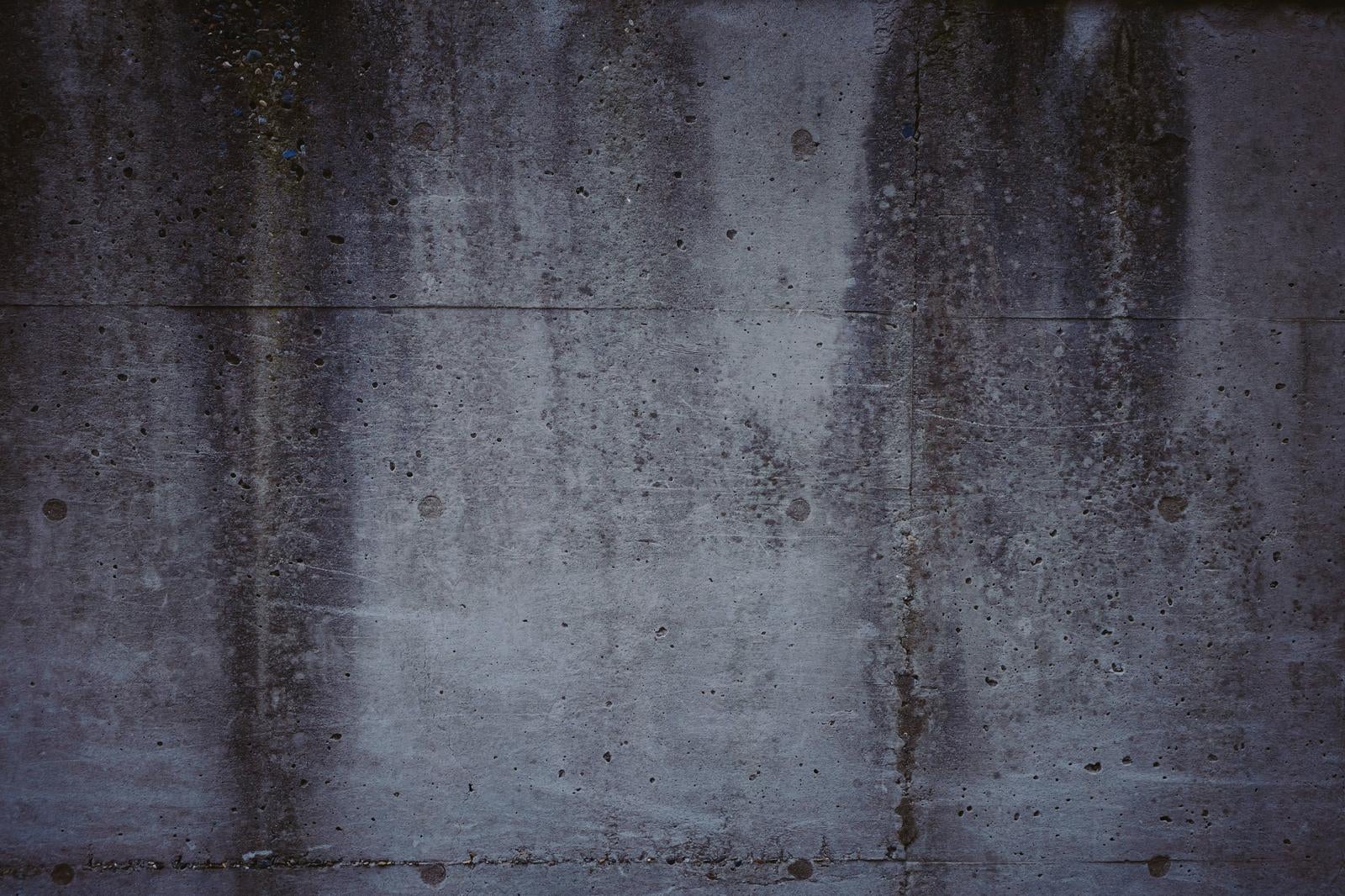 「薄汚れたコンクリートの擁壁」の写真