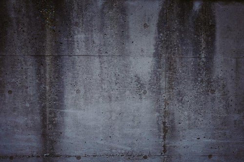 薄汚れたコンクリートの擁壁の写真