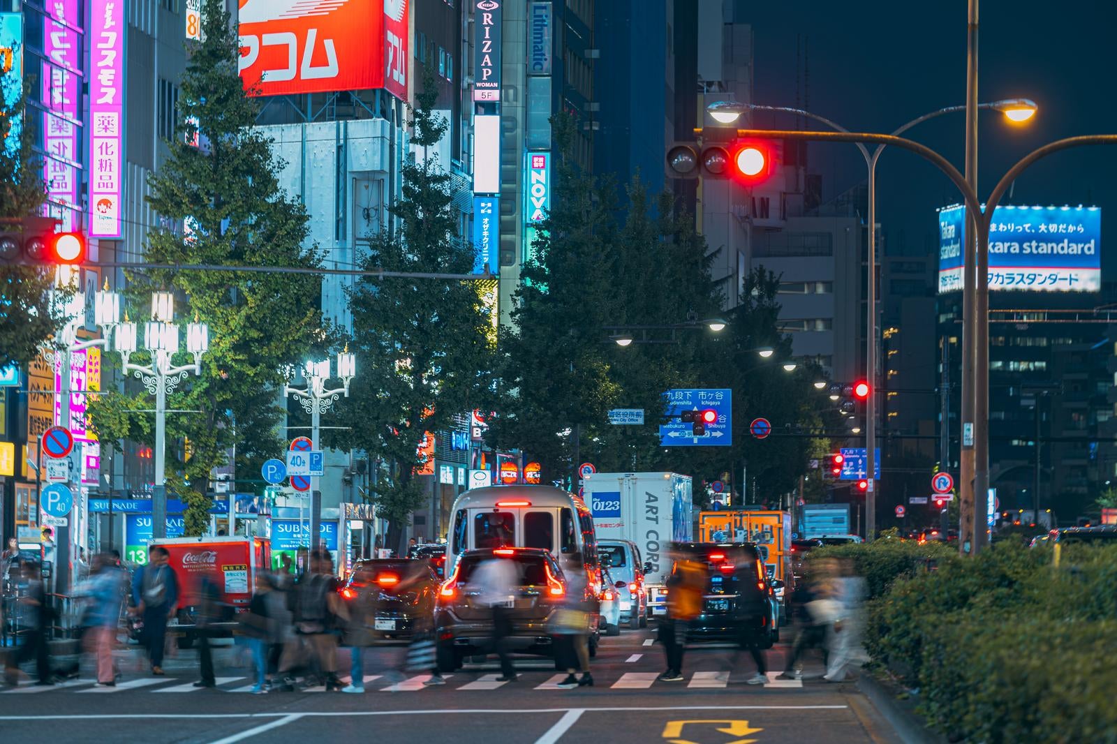 「新宿区役所前の横断歩道を渡る人（夜間）」の写真