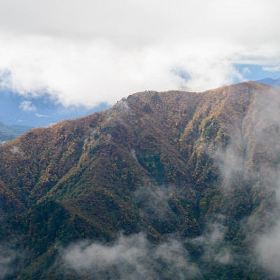 雲がかかる谷川連峰の秋の写真