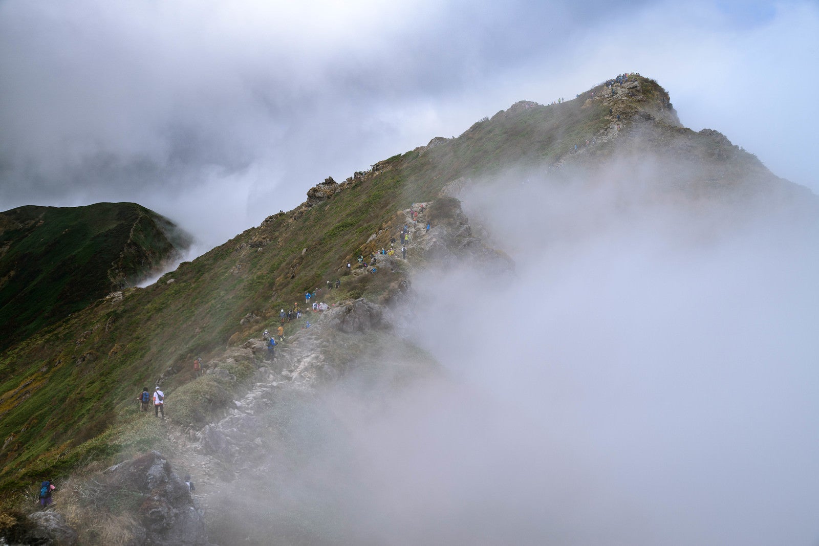 「谷川岳（オキの耳）の尾根に集まる登山者達（秋）」の写真