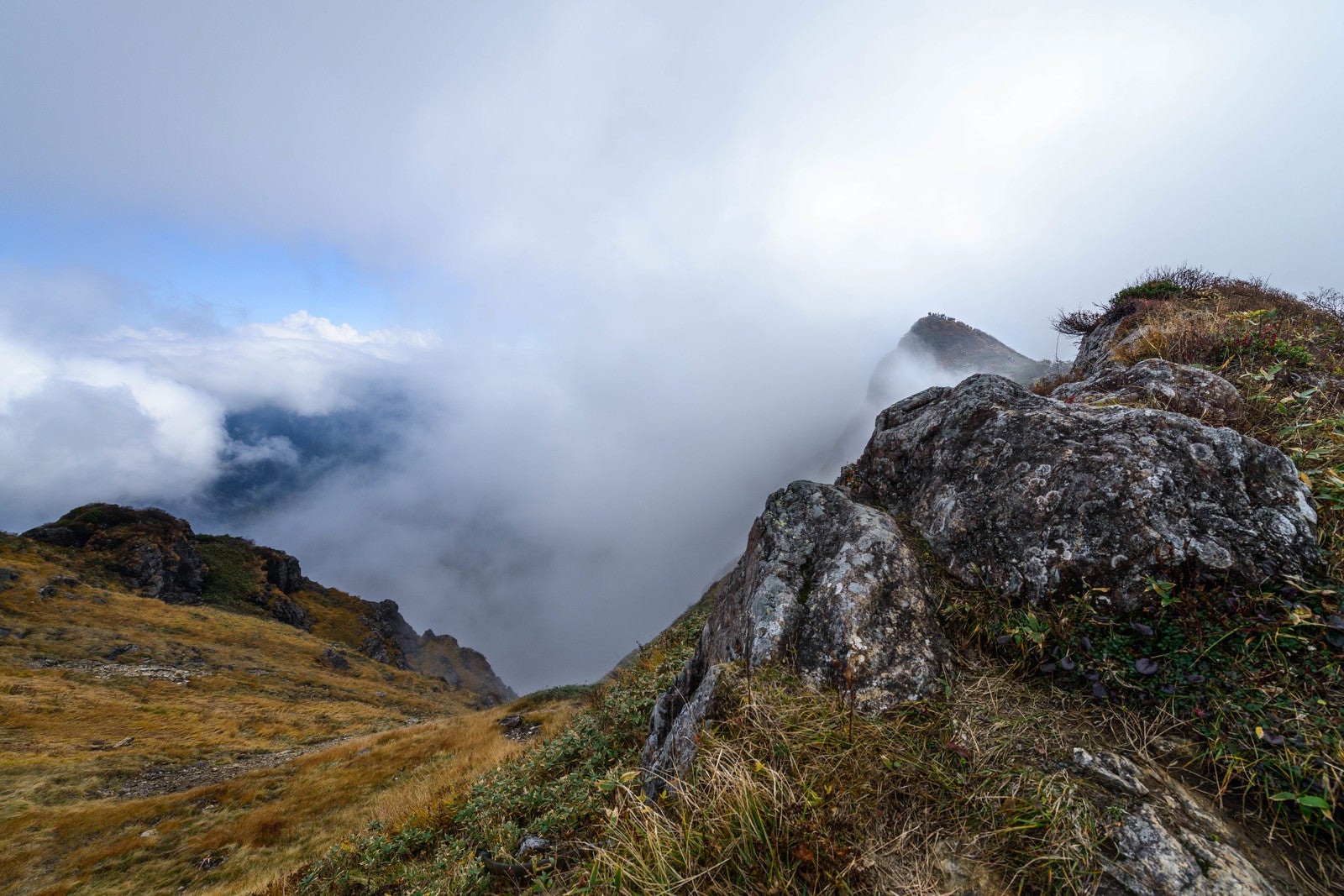 「山頂に登るも雲で景観を遮られる」の写真