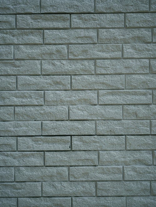 凹凸のあるブロックタイルが敷き詰められた壁（テクスチャー）の写真