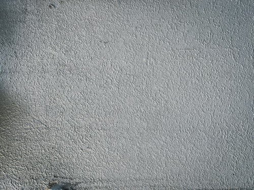 薄暗いモルタル壁のテクスチャーの写真