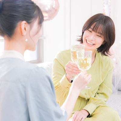 シャンパンで乾杯する女性の写真