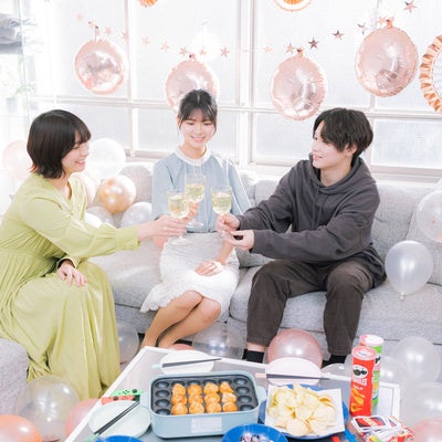 ホームパーティーで乾杯する男女の写真