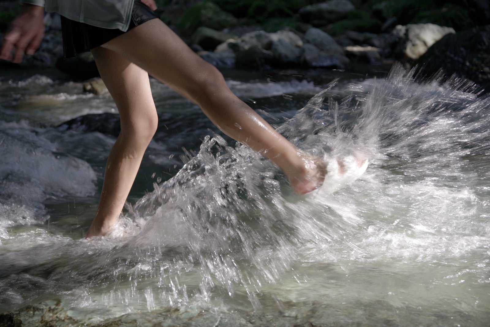 「渓流で水遊びする子供（足元）」の写真
