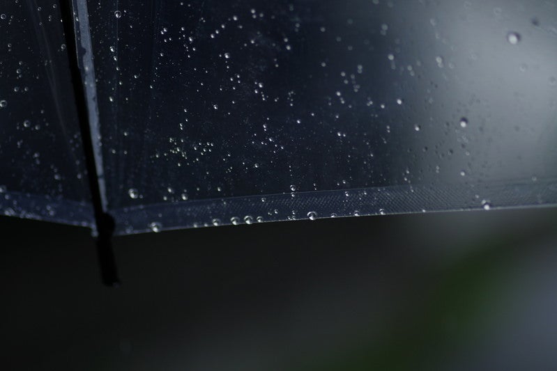 透明な傘に残る雨のしずくの写真