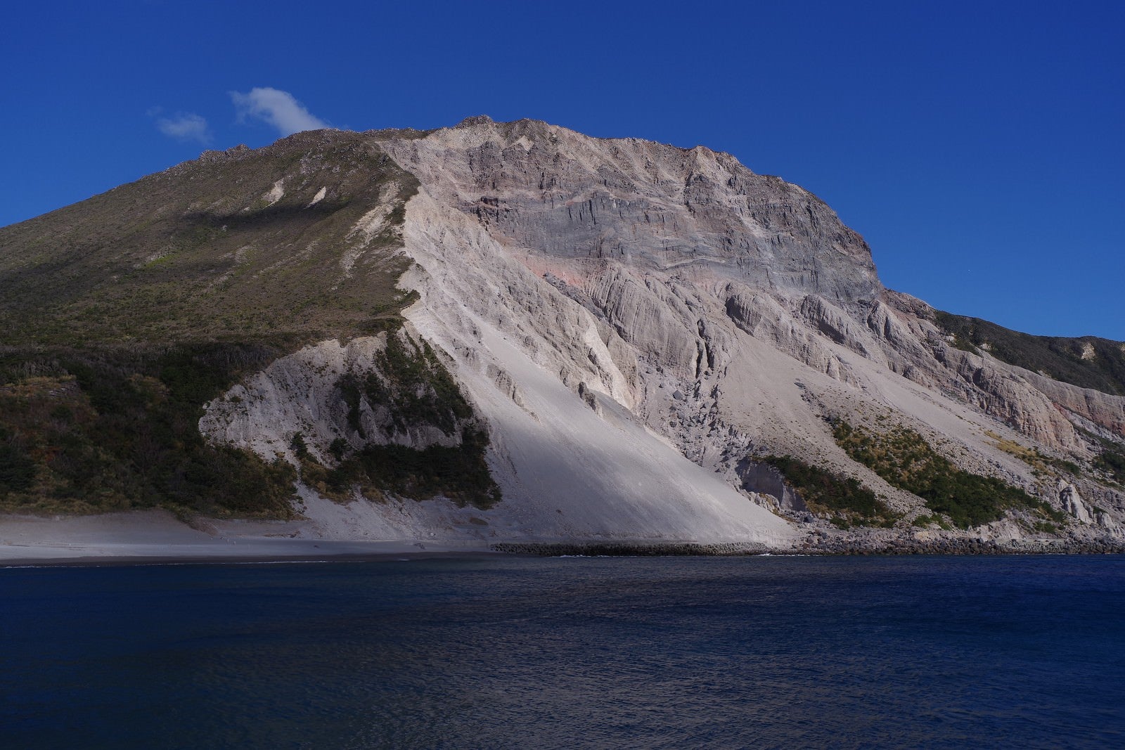 「神津島の多幸湾から見える斜面が崩れた山」の写真