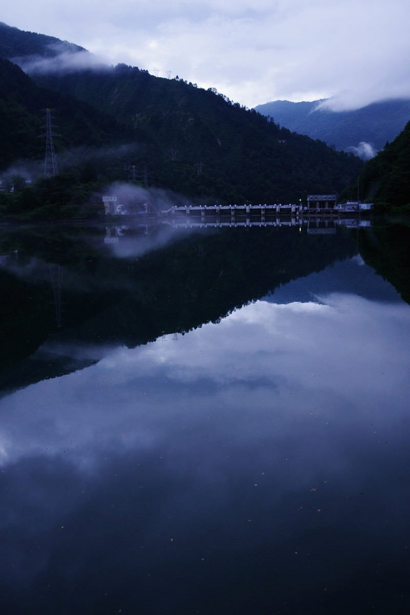 「ダム湖に反射する空模様（富山県南砺市）」の写真