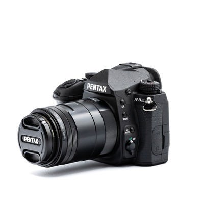 一眼レフカメラ PENTAX K-3MarkⅢに100mmマクロレンズを装着した様子の写真