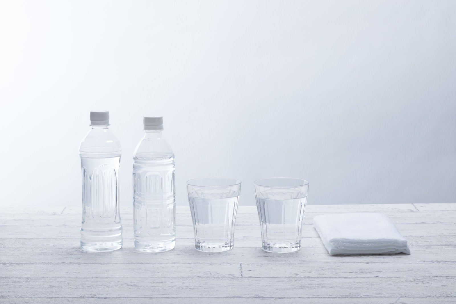 「ペットボトル2本とグラスの水」の写真