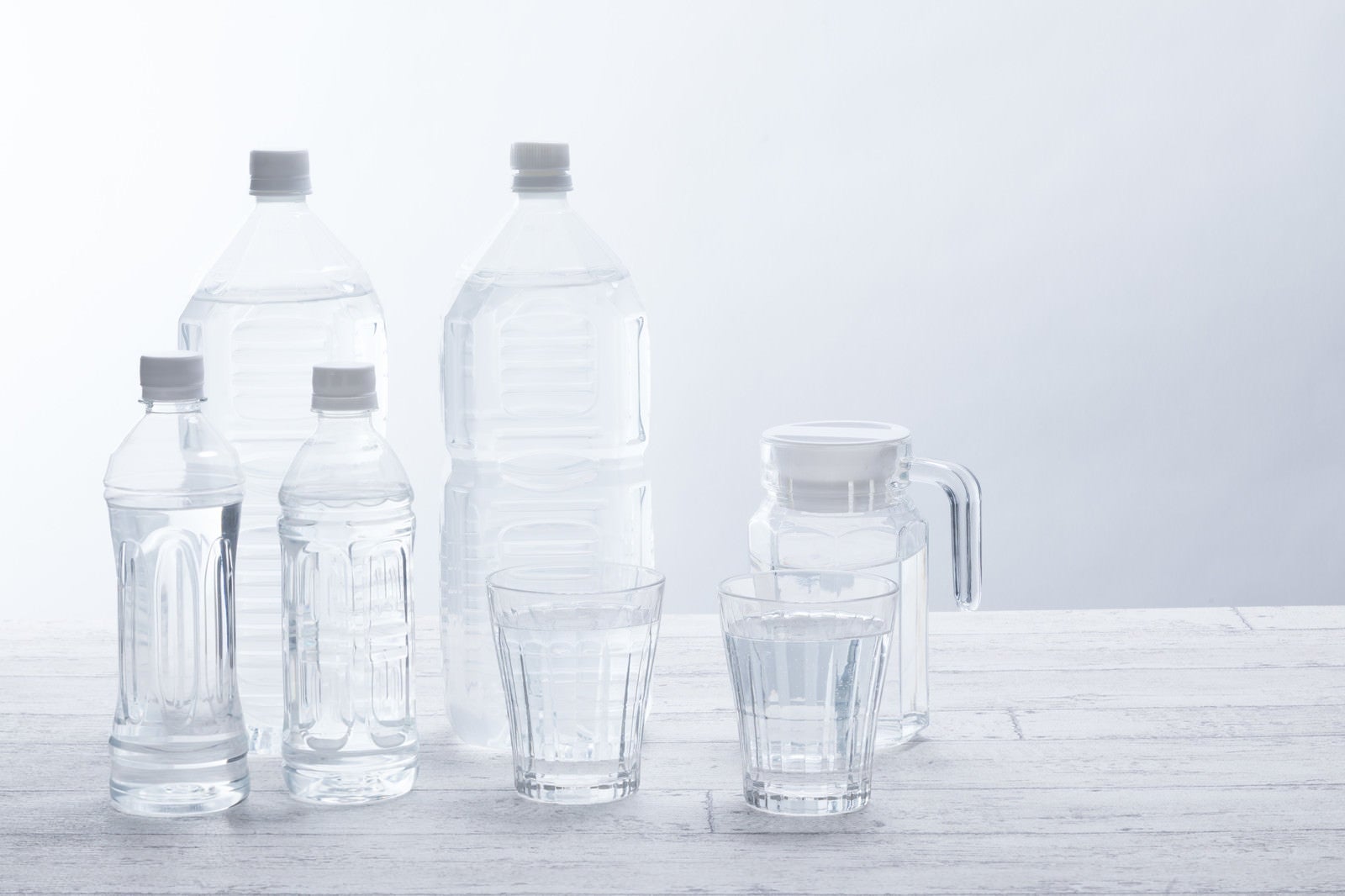 「テーブル上の飲料水（ペットボトルグラス）」の写真