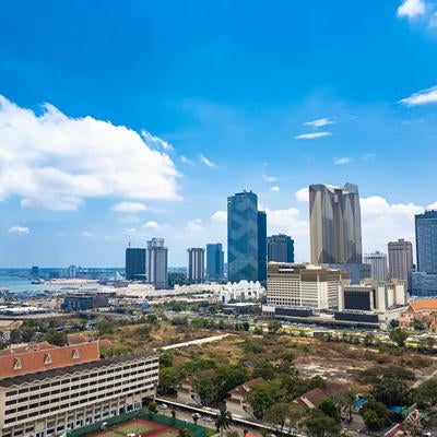 青空と白い雲を背景にした高層ビルが立ち並ぶプノンペンの都市風景の写真