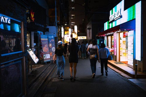 新大久保の路地裏と夜道を歩く人の写真