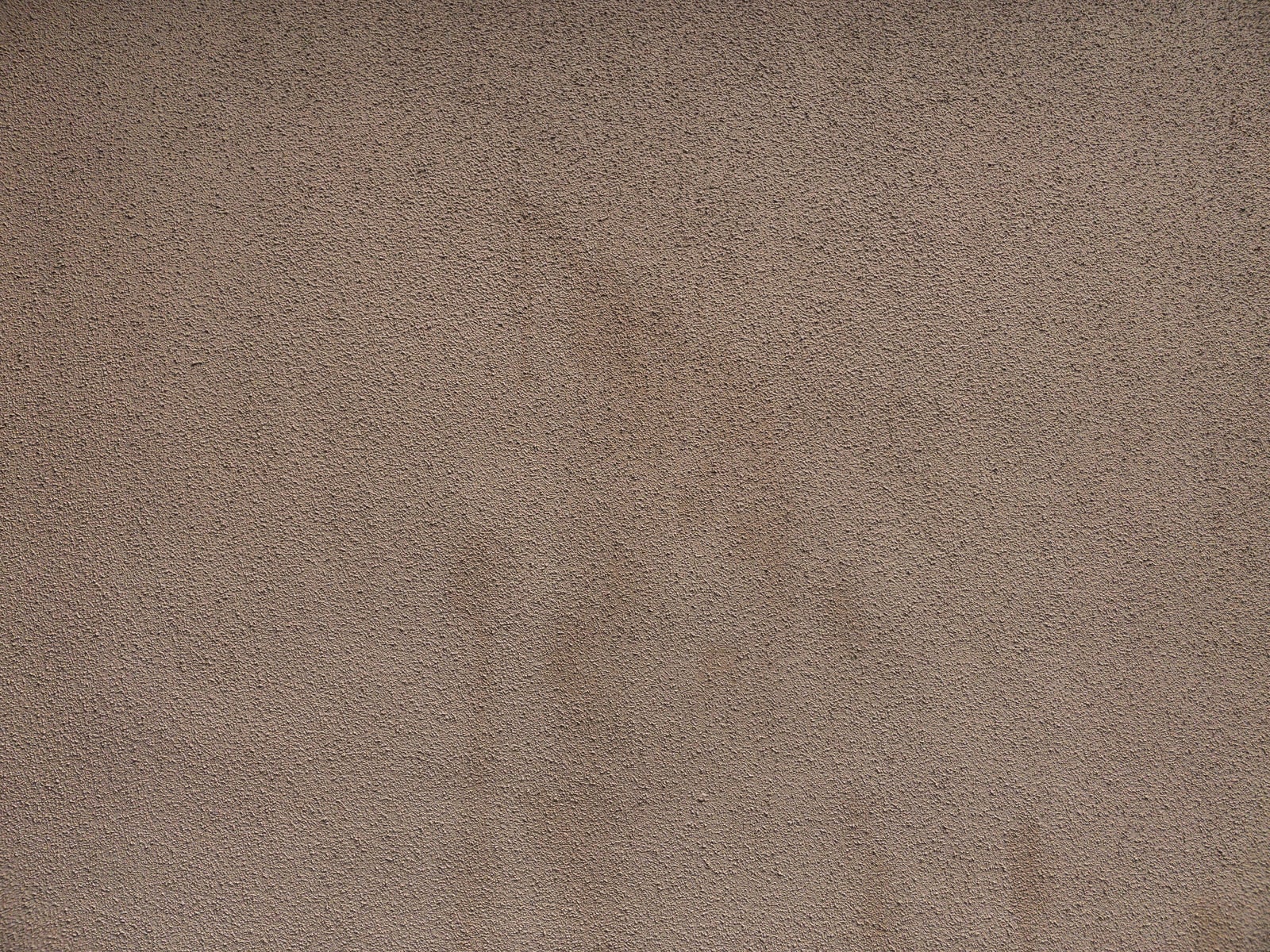 「シミが残るモルタル仕上げの壁」の写真