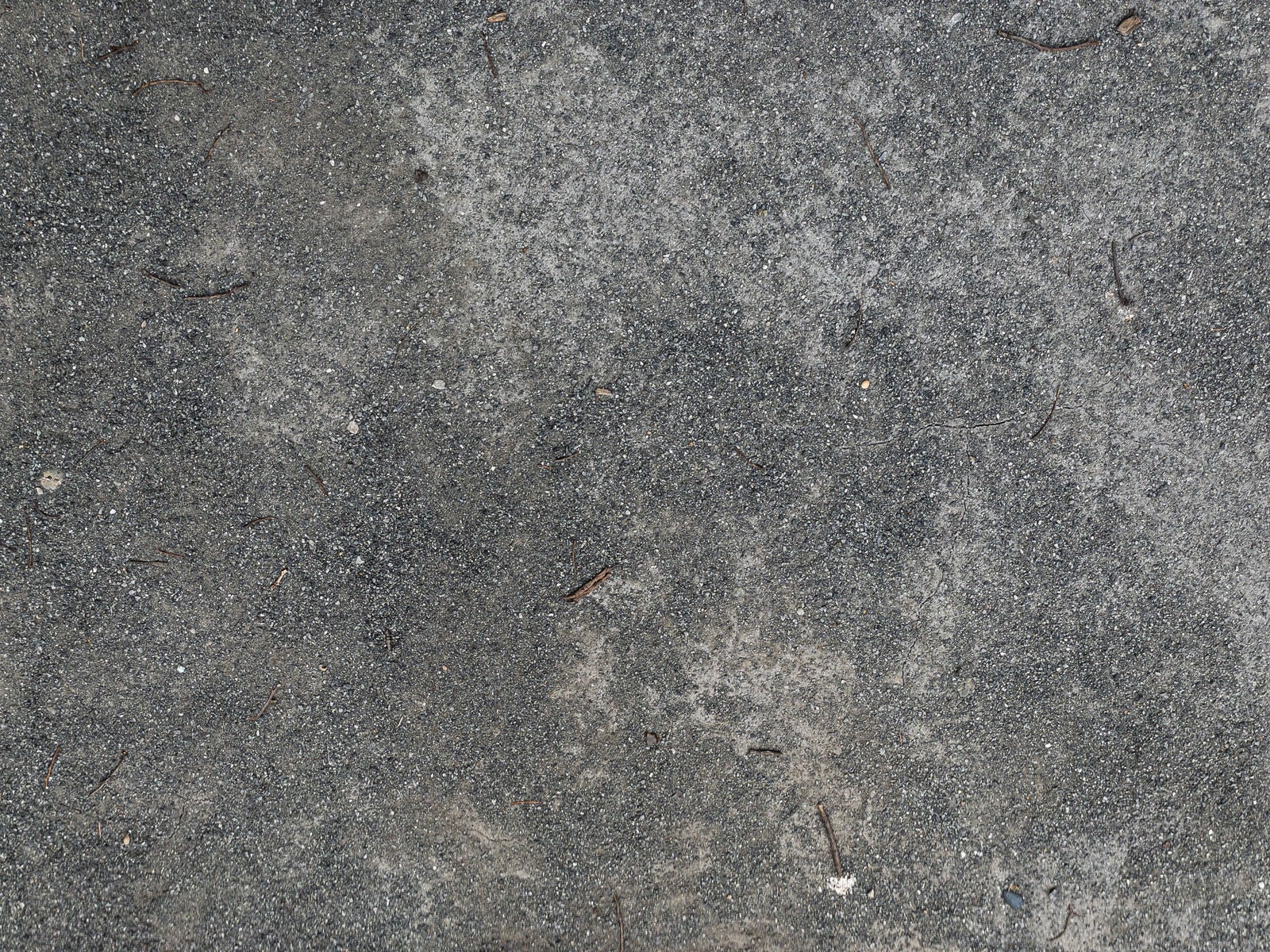 「コンクリートの地面の上に散らばる砂」の写真