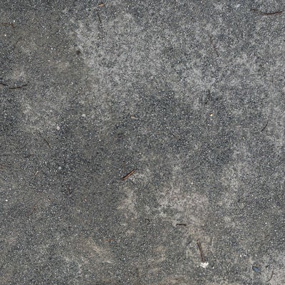 コンクリートの地面の上に散らばる砂の写真