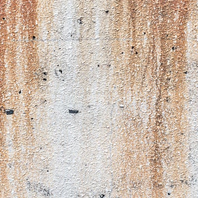 モルタル壁と流れ落ちる錆の写真