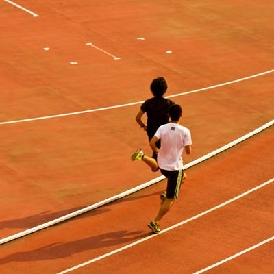 競技場を走る陸上選手の写真