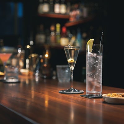 BARカウンターに置かれたマティーニとジントニックの写真