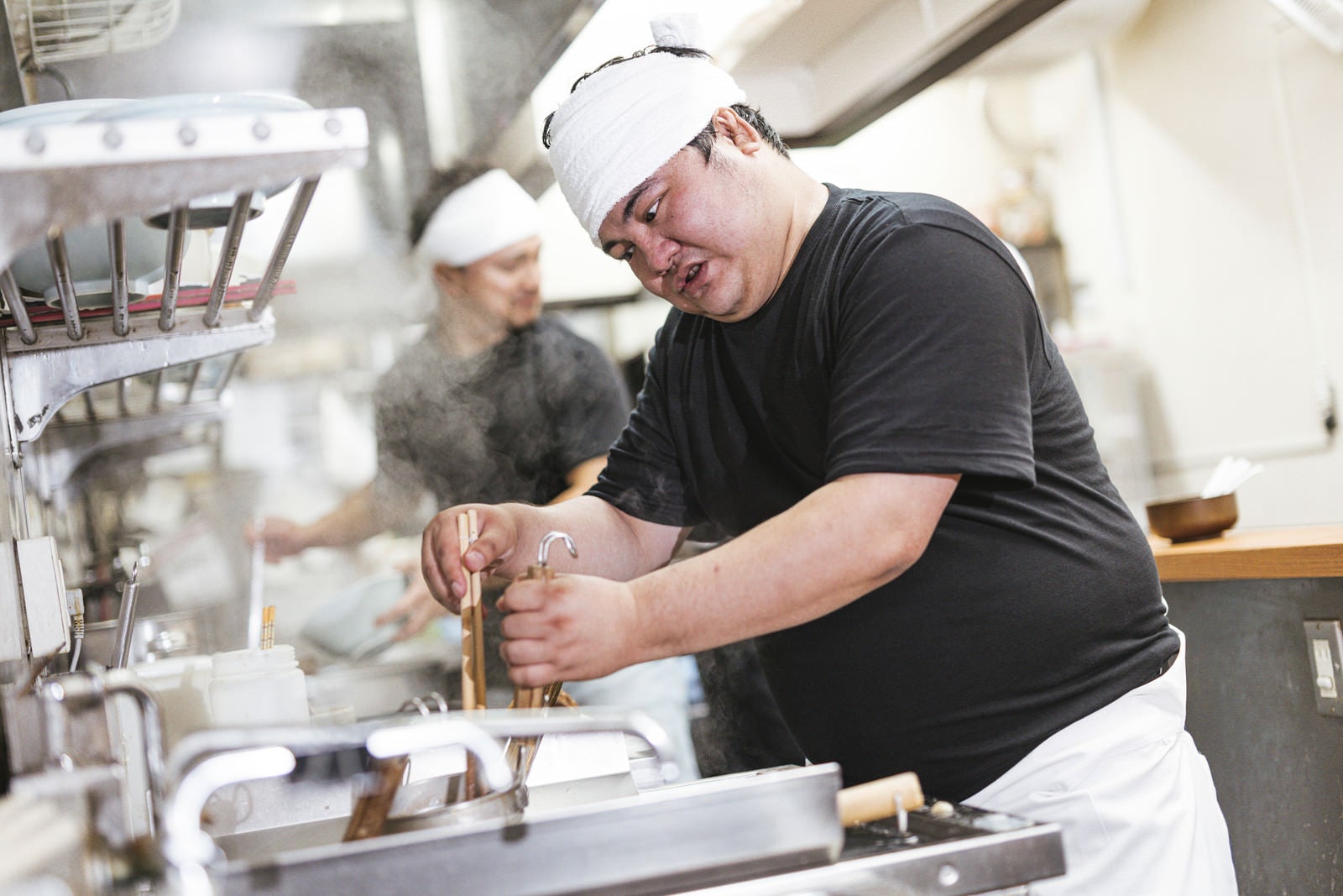 「麺の硬さを見極めるラーメン職人」の写真［モデル：段田隼人］