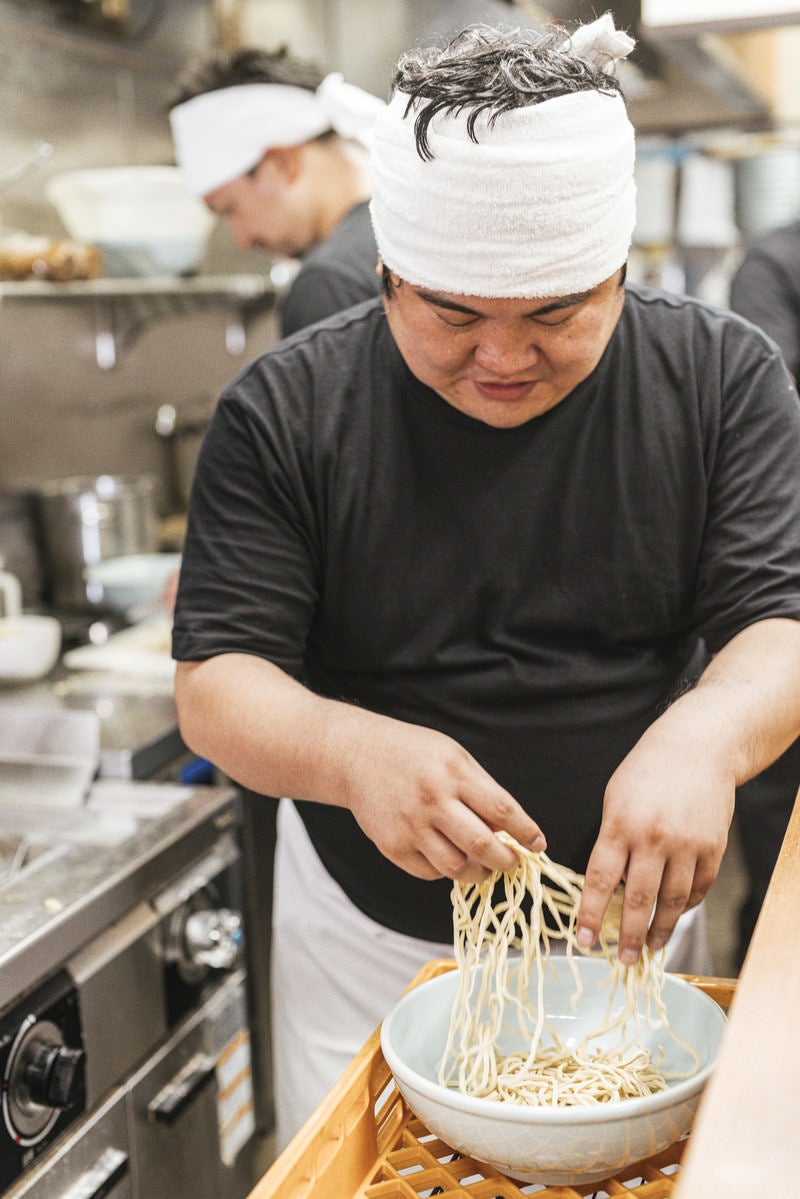 「茹でる麺を準備するラーメン店主」の写真［モデル：段田隼人］