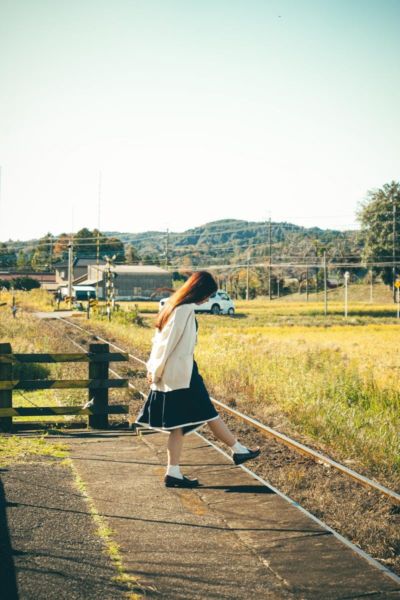 「のどかな田舎町の駅のホームと女性」の写真［モデル：ラミエル］