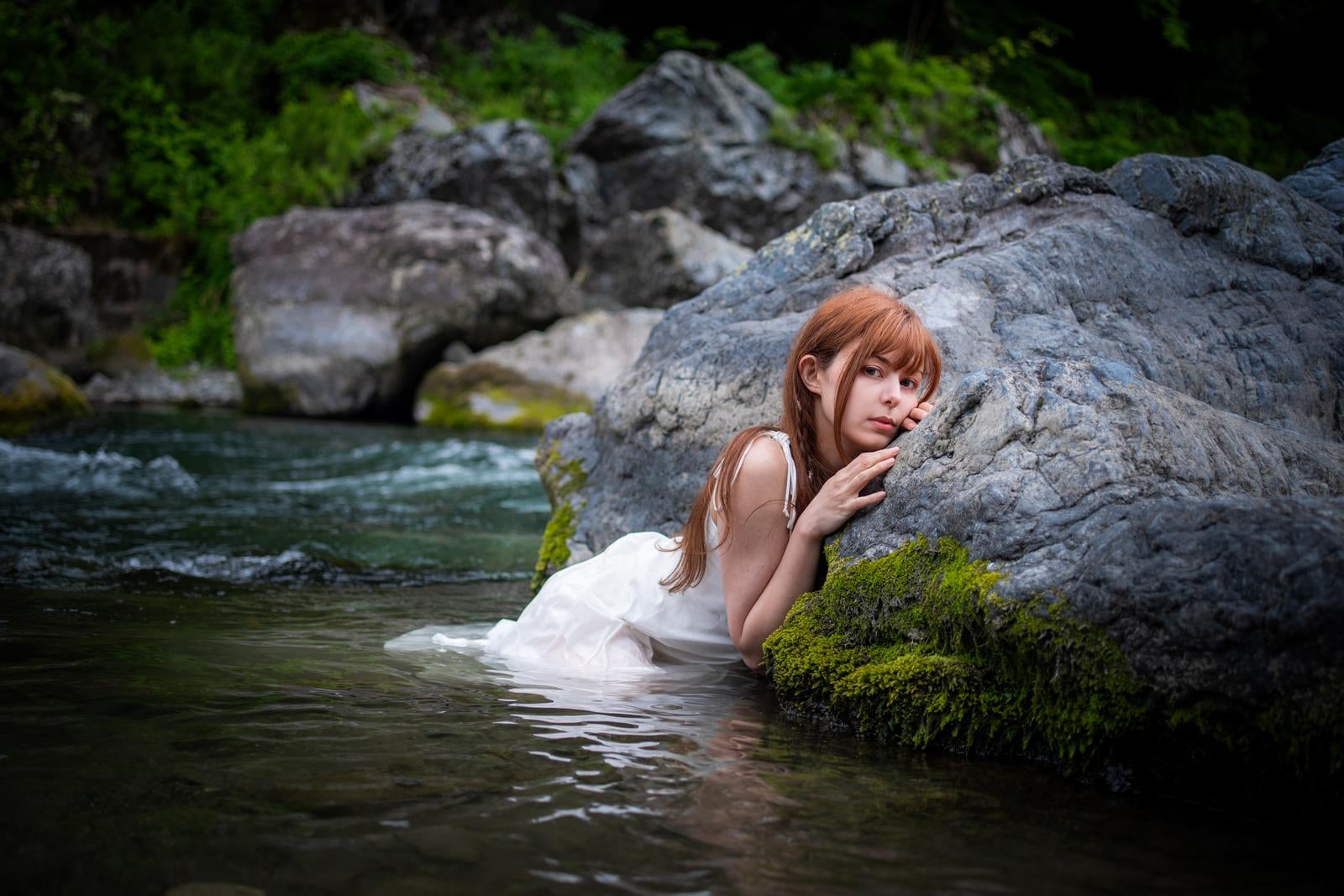 「川の水に浸かる白いドレスの女性の美しいポートレート」の写真［モデル：ラミエル］