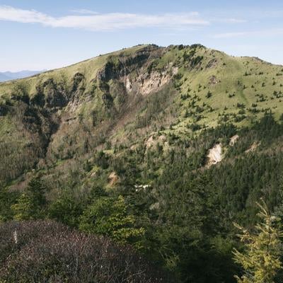 四阿山登山道から見る岩肌が露出した根子岳の写真