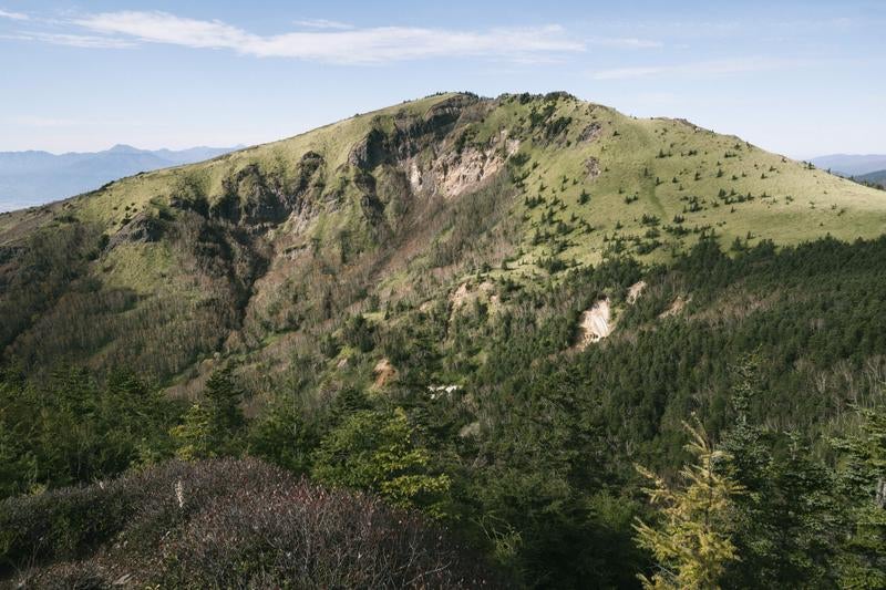 四阿山登山道から見る岩肌が露出した根子岳の写真