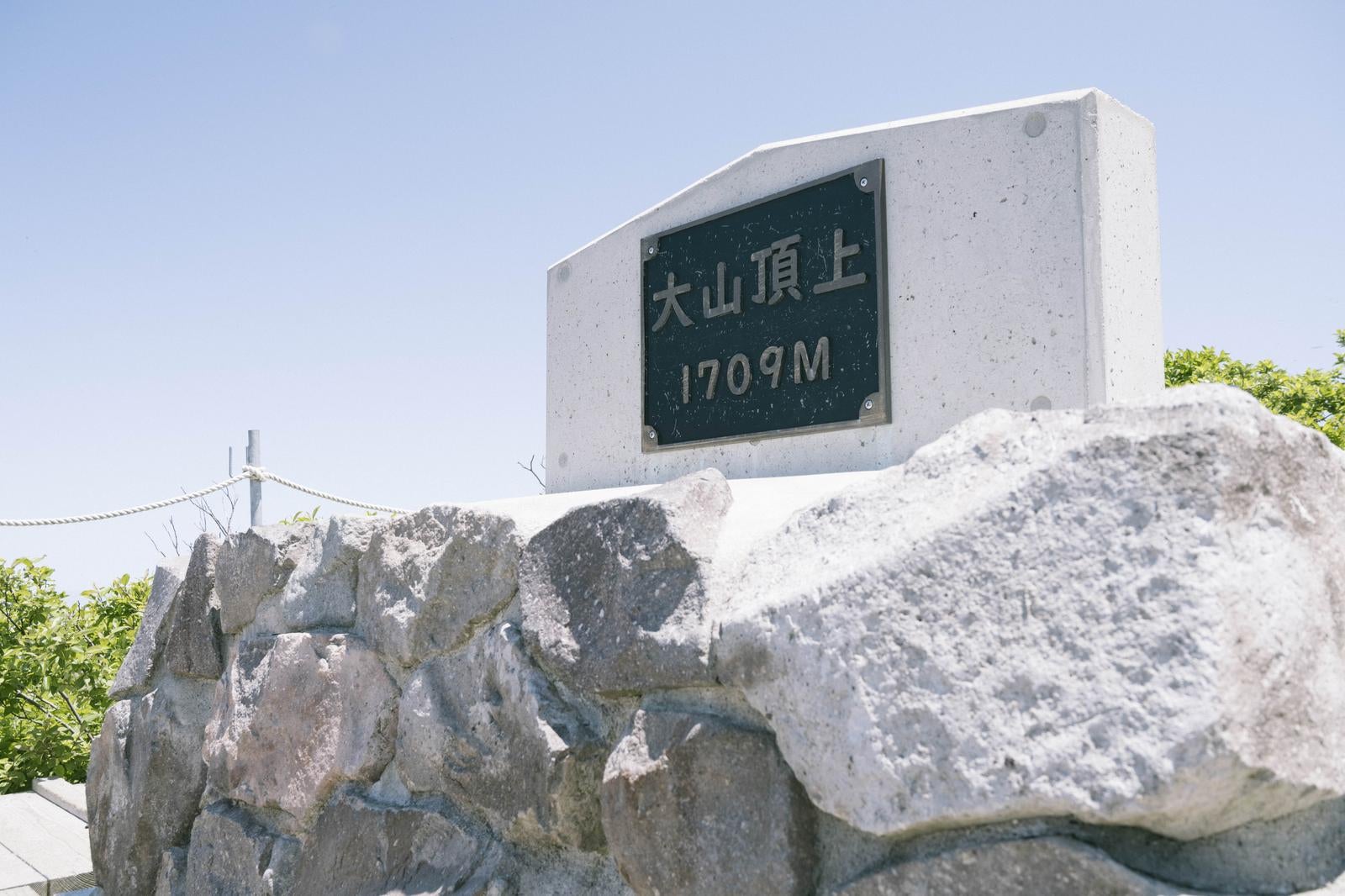 「石積みの台座の上に設置された伯耆大山山頂標」の写真