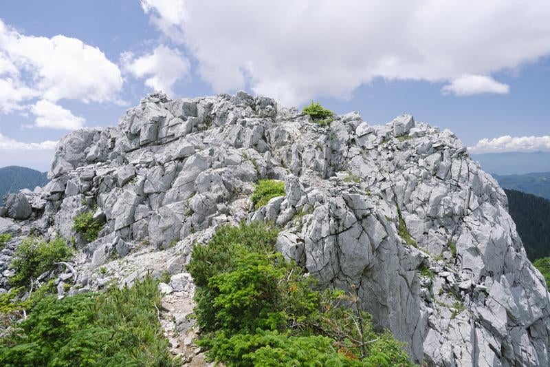 雄大な白亜の光岩と青空が織りなす山岳風景の写真