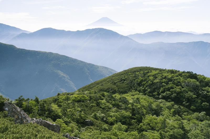 重なり合う稜線と遠景の富士の写真