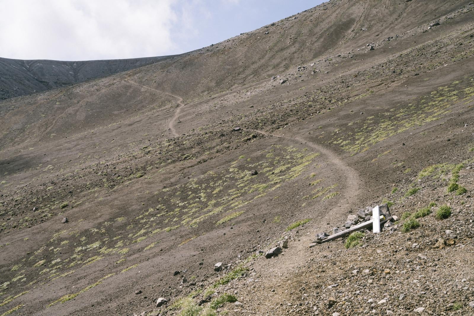 「荒涼とした山肌を切り裂く十勝岳登山道」の写真