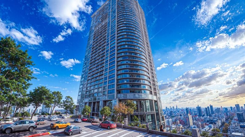 高層マンションと高台の駐車場の写真