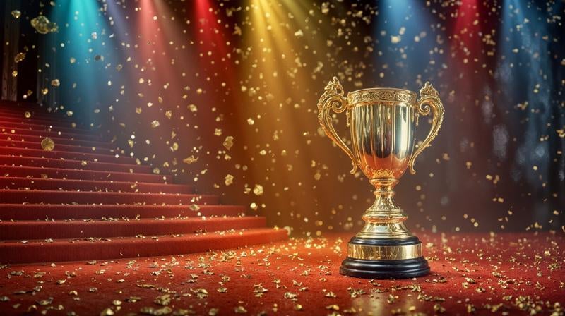 黄金のトロフィーが置かれているレッドカーペットの写真