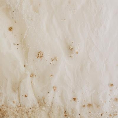 ホワイトベースに茶色い土汚れと粒状のシミが点在する古い紙テクスチャの写真