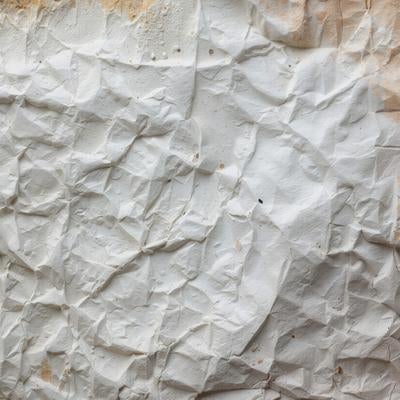 土埃と白いペイントがまみれた壁面のしわと凹凸感の写真