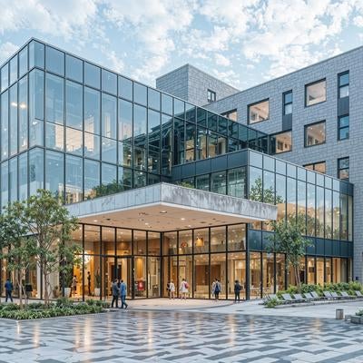 青空に映えるガラス張りのモダンな建築の写真