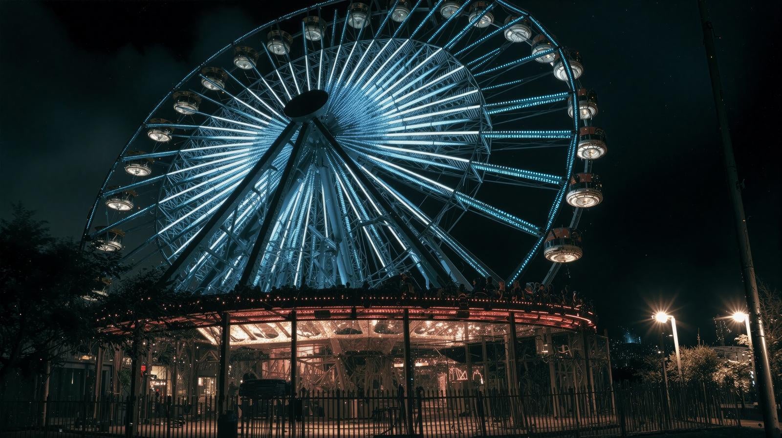 「観覧車の灯りとともに広がる夜の遊園地」の写真