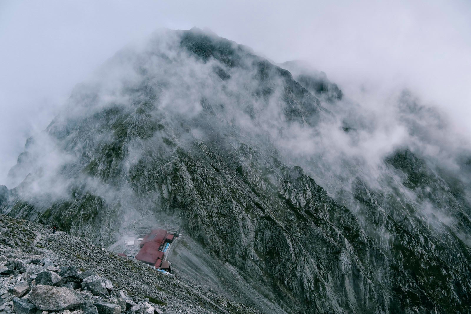 「ガスに包まれる穂高岳山荘と奥穂高岳」の写真